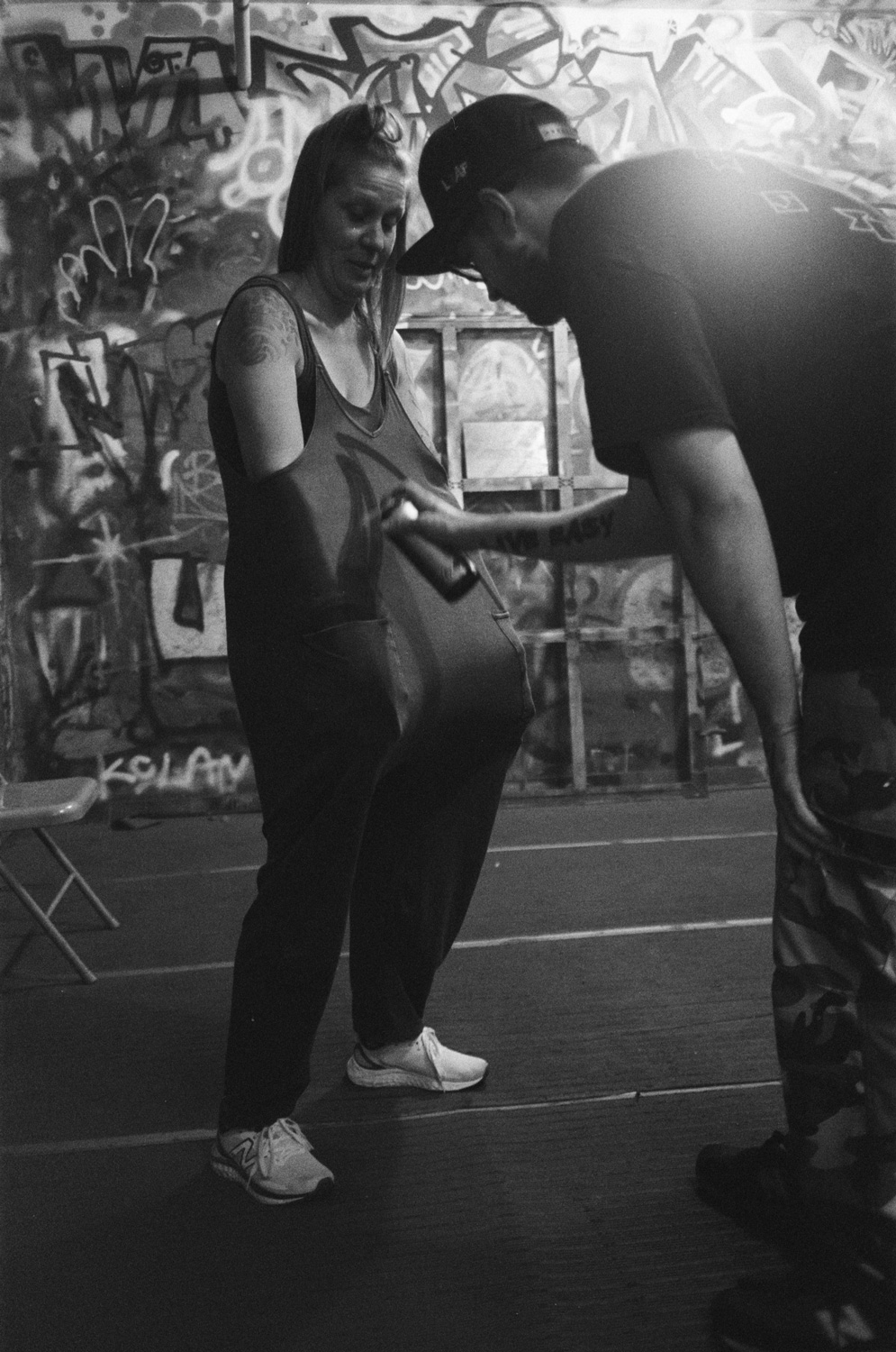 Black and white candid photo of two people spray painting graffiti art